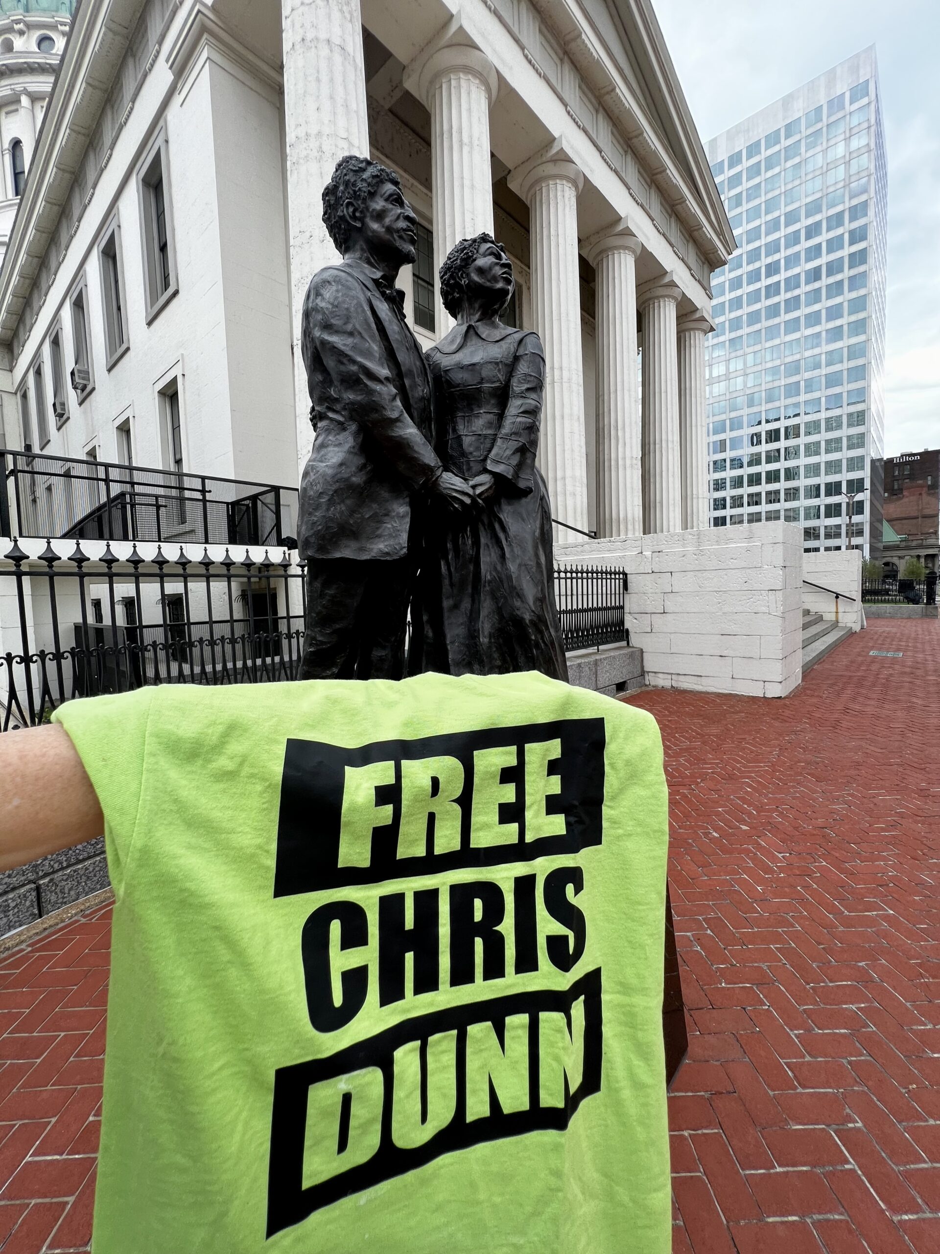 Free Chris Dunn shirt displayed in downtown St. Louis next to Dred and Harriet Scott statue